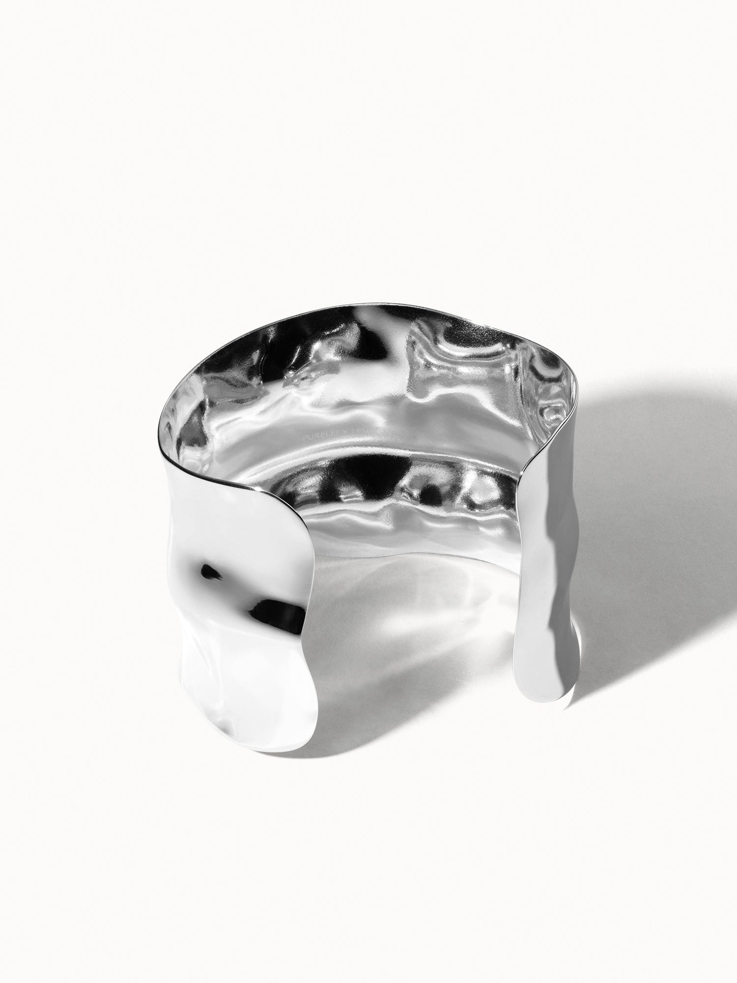 Silbernes, gewelltes Armband von PURELEI mit glänzender Oberfläche und modernem Design.