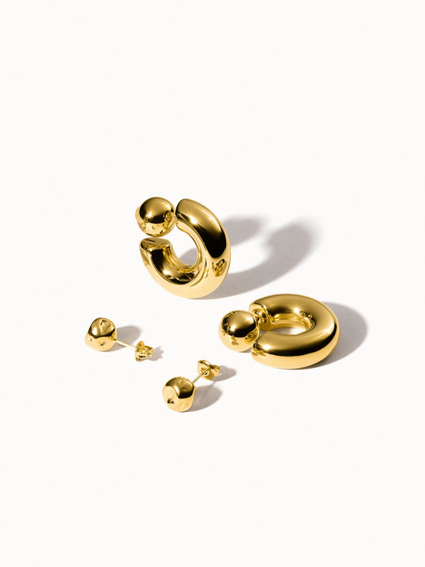 Goldene Creolen und Ohrstecker von PURELEI, glänzend und modern, elegant und feminin.