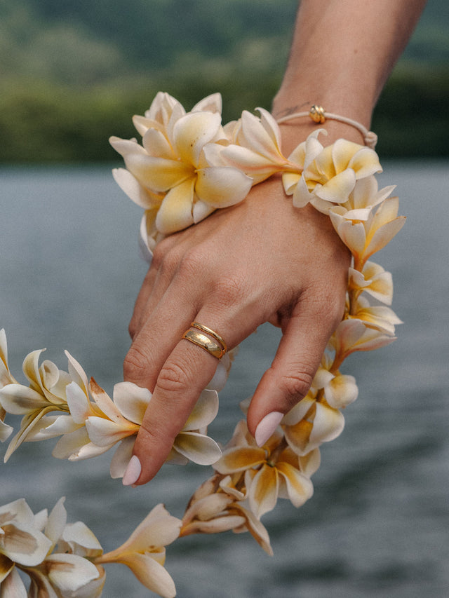 PURELEI Twin Tides Ring aus 18K vergoldetem Edelstahl an Hand mit tropischem Blumen-Lei, elegant und feminin.