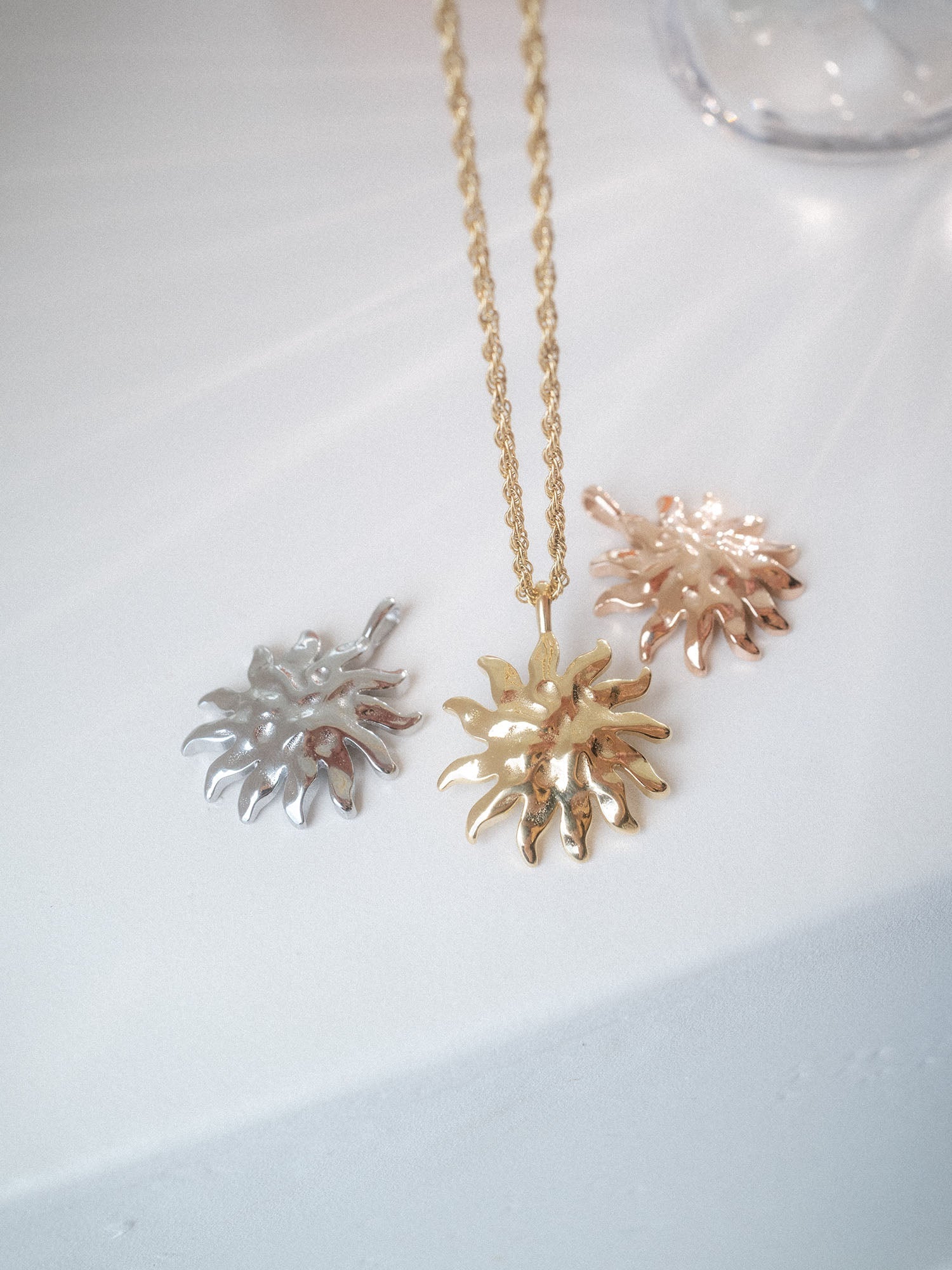 Iconic Sun Charm in Gold, Silber und Roségold, nickelfrei, mit strukturierter Sonnenform und hochwertiger PURELEI-Ästhetik.
