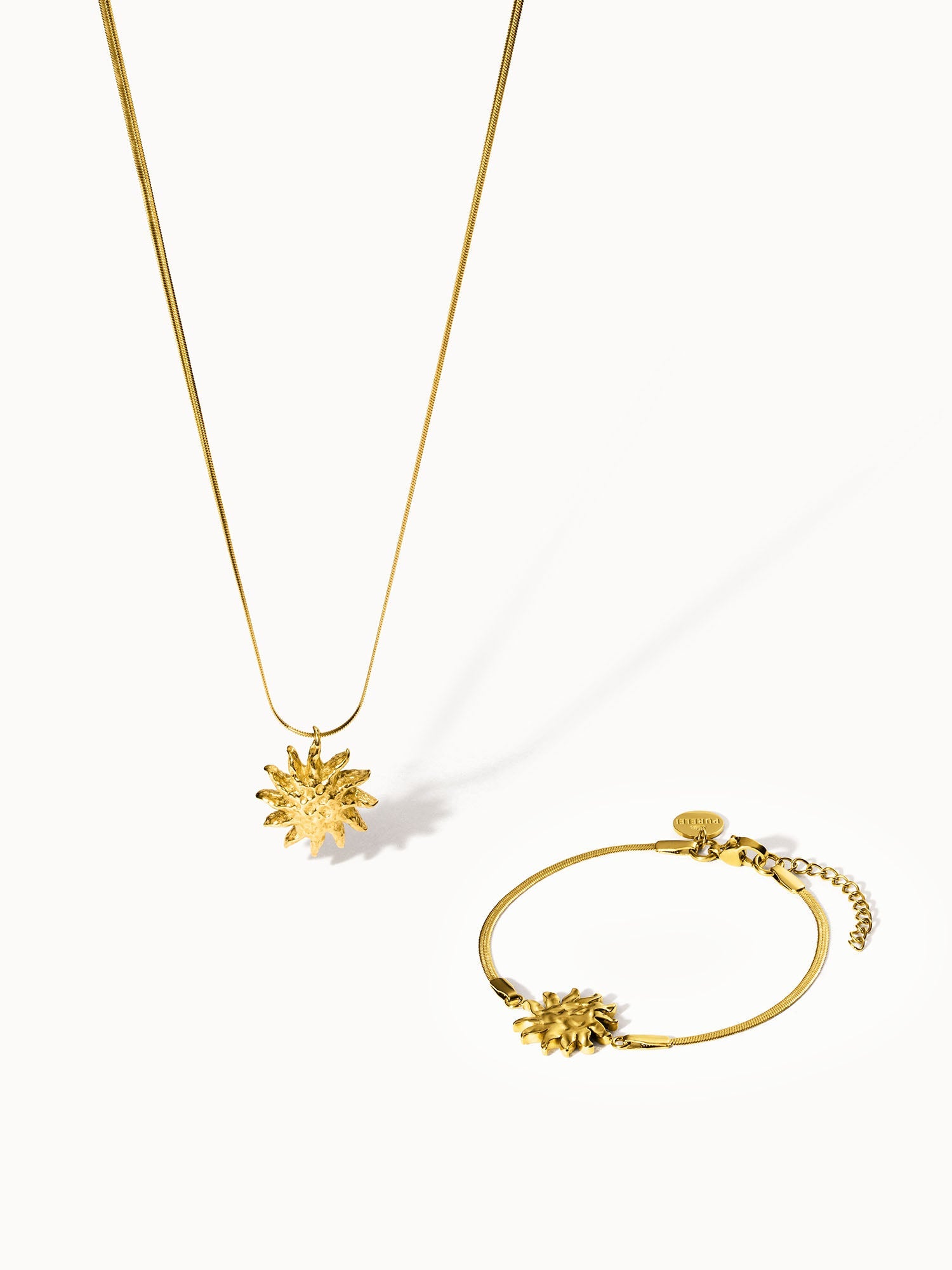 Goldene Kette und Armband mit Sonnenmotiv von PURELEI, elegant und strahlend.