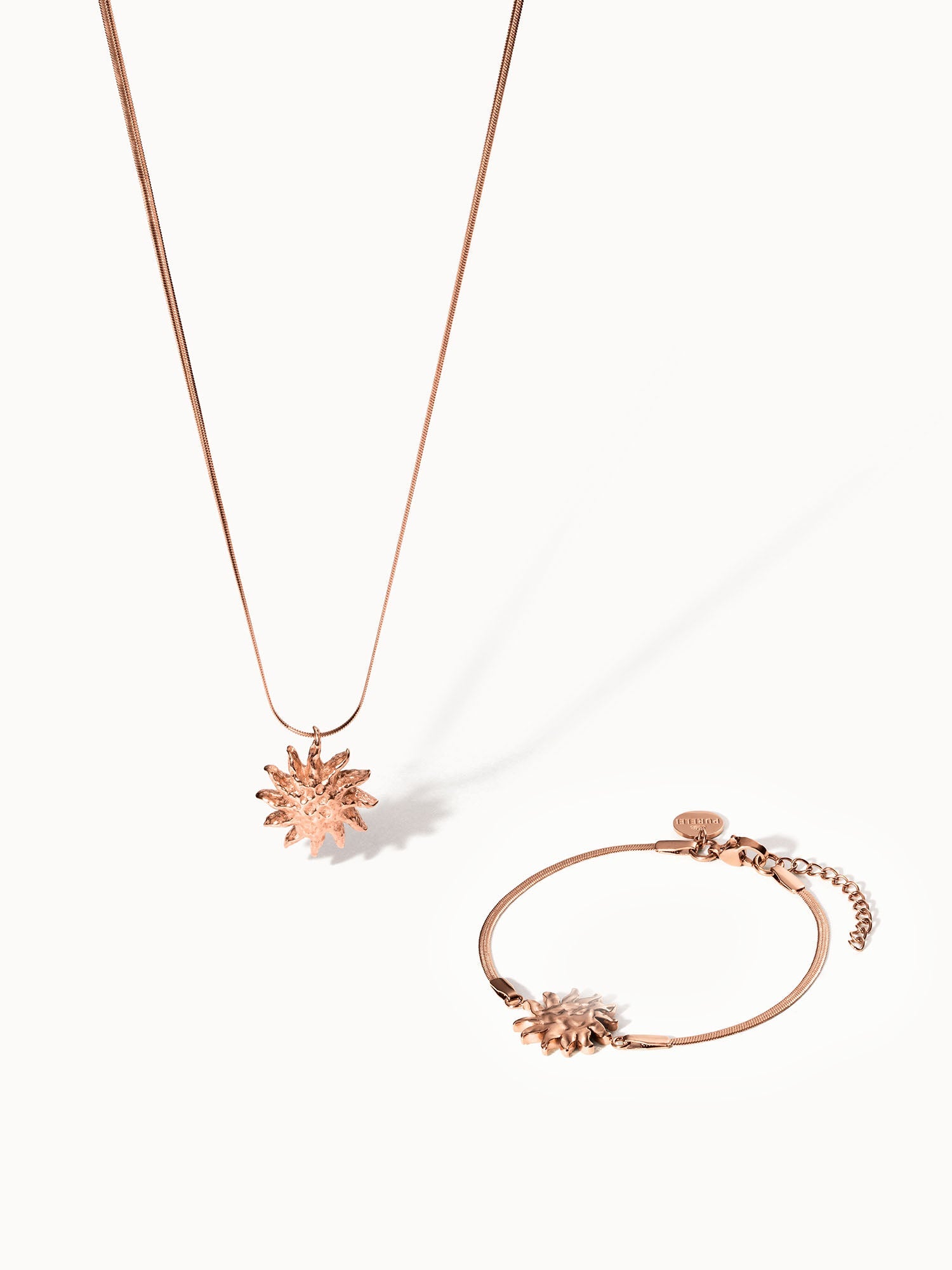 Roségoldene Kette und Armband mit Sonnenmotiv von PURELEI, elegant und feminin.