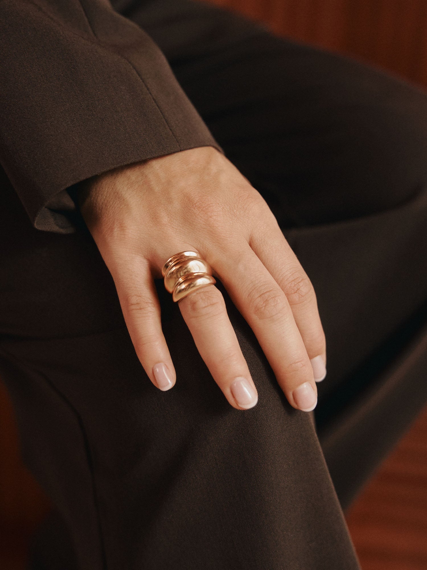 Roségoldener Ring mit geschwungenem Design, getragen von einer Hand, inspiriert von PURELEI.