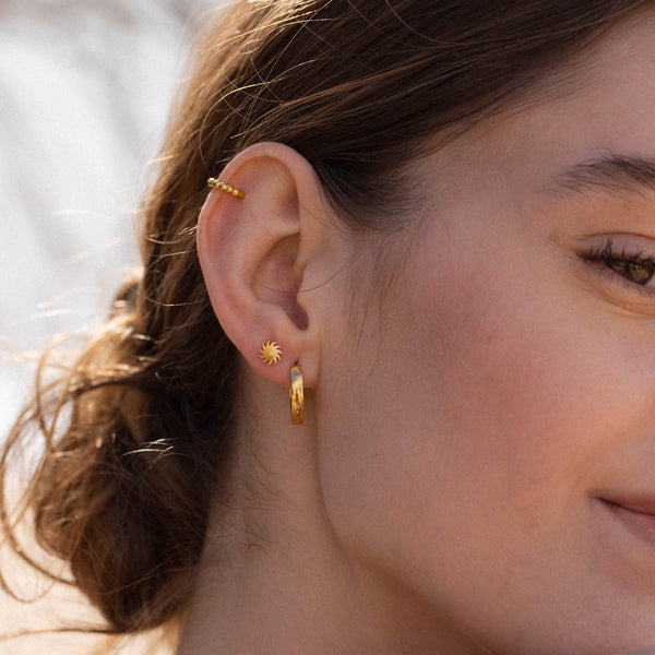 Roségoldene Creolen und Sonnenohrringe von PURELEI, elegant und strahlend.