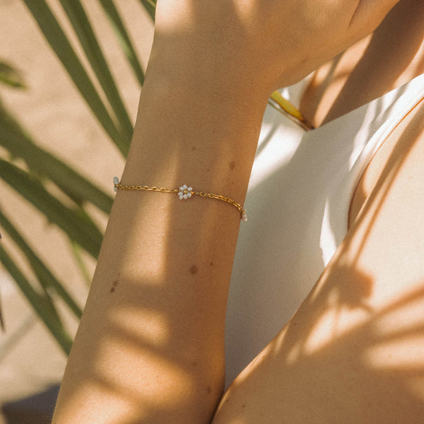 Roségoldenes Armband mit blütenförmigem Design, getragen im warmen Sonnenlicht – PURELEI.